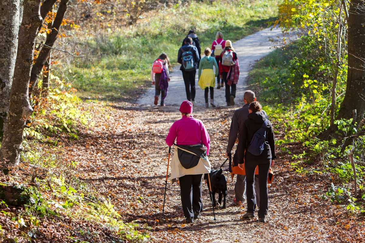 Famiglia che fa trekking tra i sentieri del Parco della Murgia Materana, paesaggi rupestri e chiese in grotta sullo sfondo